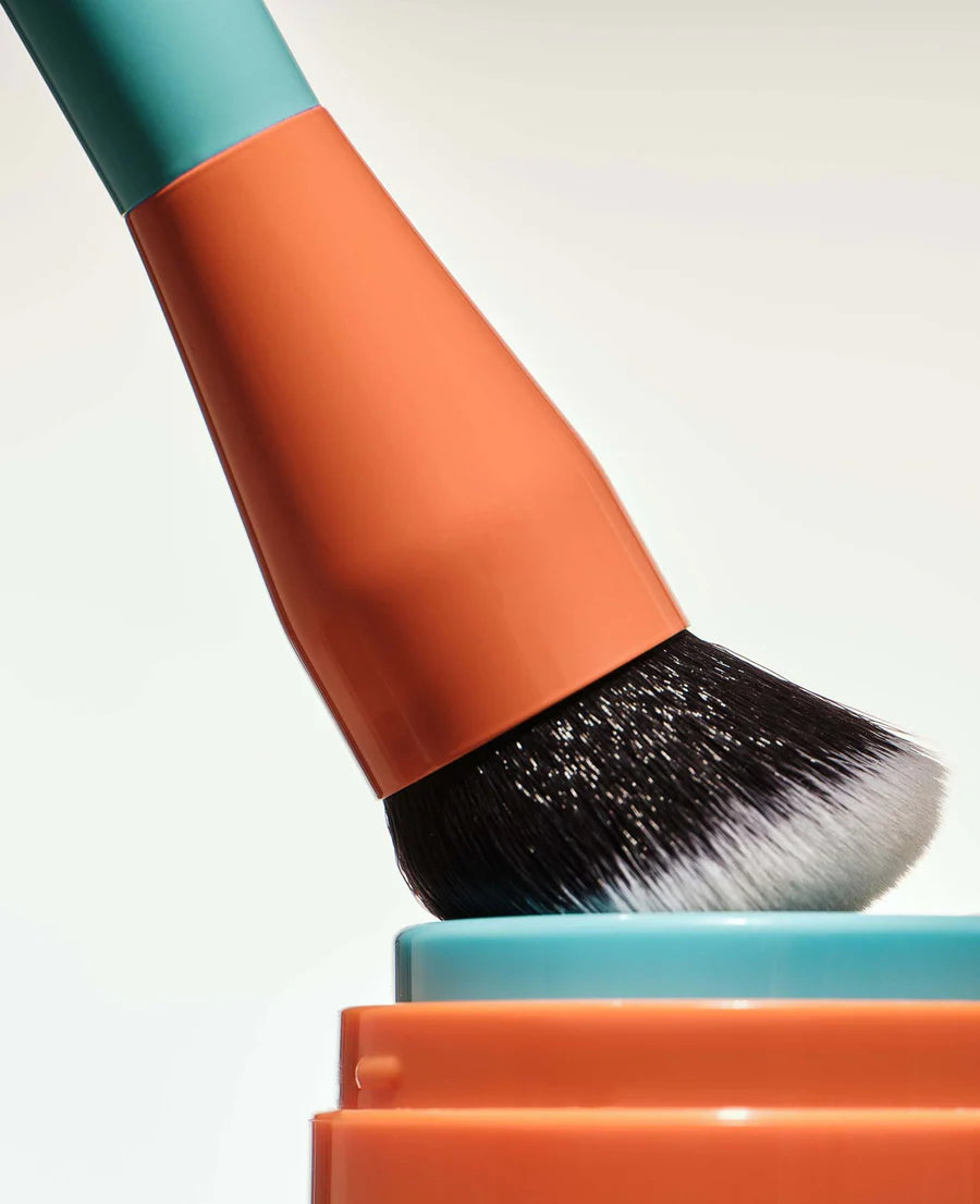 Colorful makeup brush with black bristles on a white background